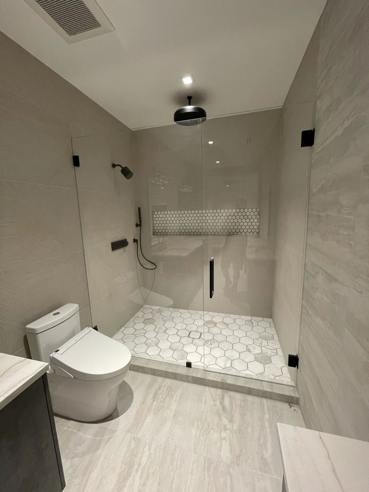 Finished master bathroom remodel with frameless glass walk-in shower and floating double vanity in Plantation, Broward County